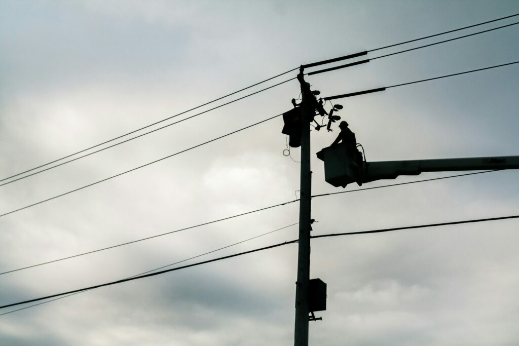 Silhouette of an Easton Utility Worker maintaining power lines during the daytime taken by the American Public Power Association via Unsplash.