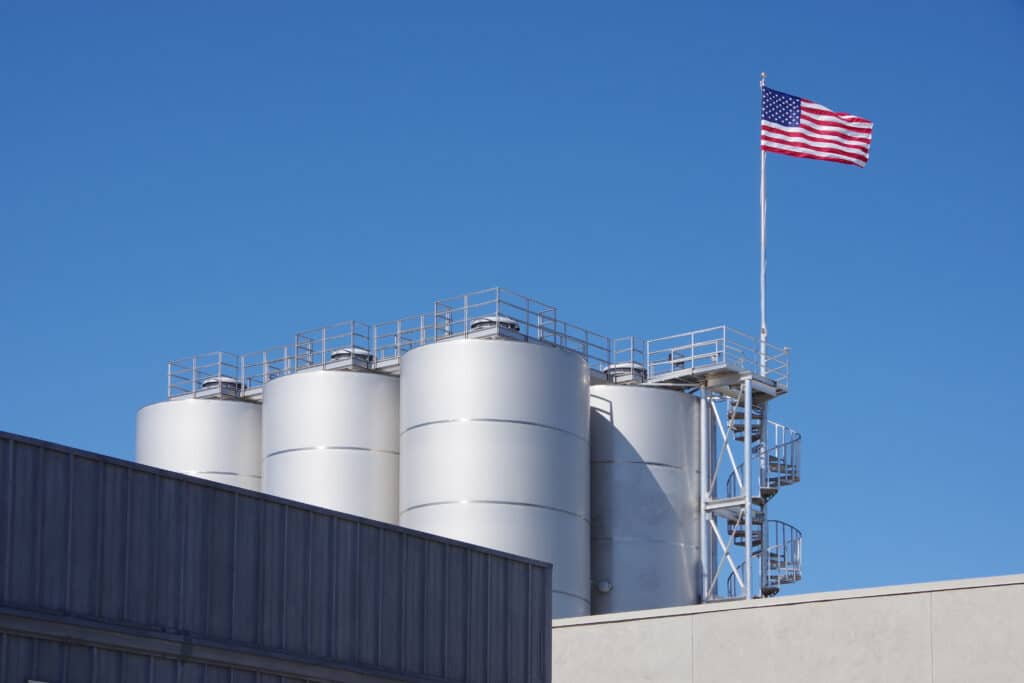 American flag flying over industrial facility Shutterstock ID#1520717213