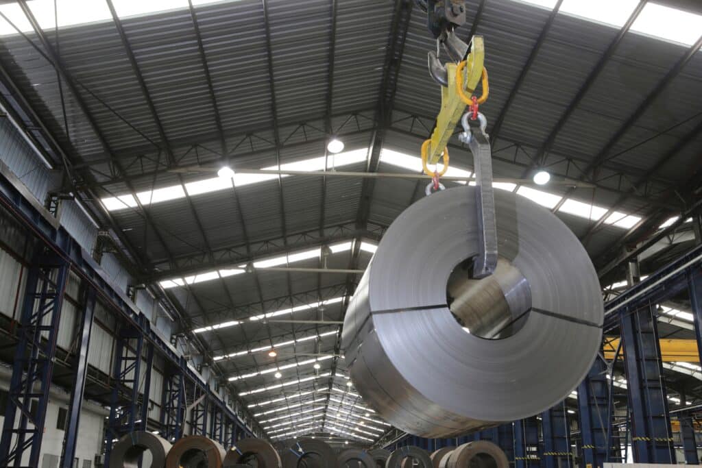 Rolled steel coil being moved in a steel industry plant, Shutterstock ID#2523349199