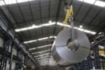 Rolled steel coil being moved in a steel industry plant, Shutterstock ID#2523349199